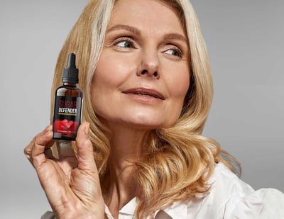 a woman with blonde hair and sugar defender bottle