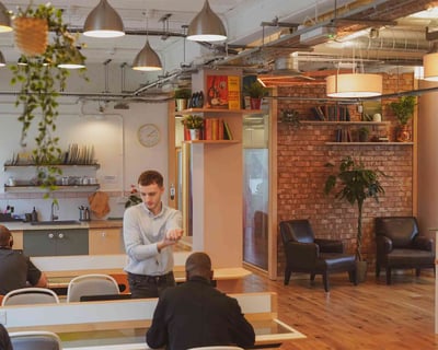 a man standing in a room with a bunch of people in a coworking place