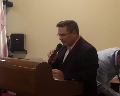 a man in a suit and tie is standing at a podium with a microphone