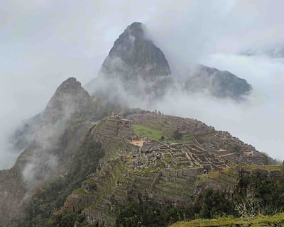 Machu Picchu surrounded by clouds in Peru.