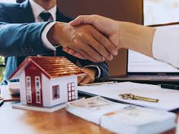a man and woman shaking hands over a desk, after discussion related to property