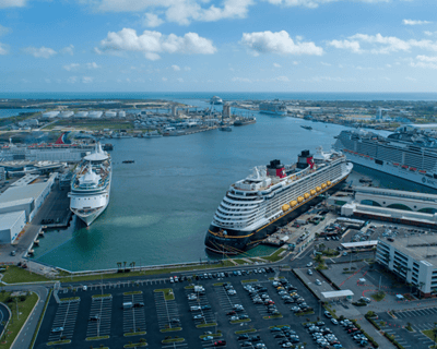 a cruise ship docked in a harbor with a cruise ship in the background