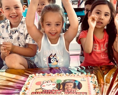 birthday girl and friends at party with birthday cake