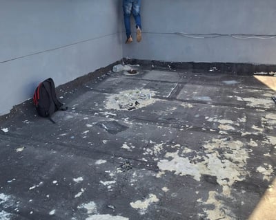 Flat roof with membrane peeling from UV exposure and thermal movement cracks