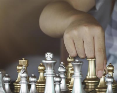 A chess student is moving chess pieces on a chess board for tactics training