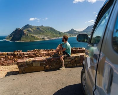 man sitting overlooking beautiful sea and sun