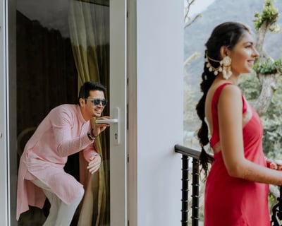 bride and groom getting fun standing on a balcony before marriage