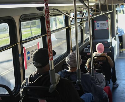 Photo of people on a bus from the back of the bus