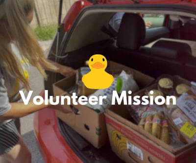 a woman is standing in front of a car with a ducky in the trunk