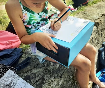 une petite fille qui colorie une image de requin