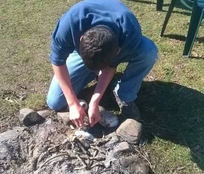 teenager making a campfire at teencampsuk