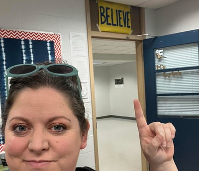 Woman with sunglasses standing in a classroom