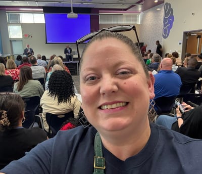 Selfie photo with organization meeting in background