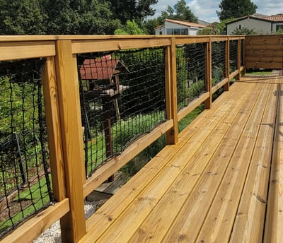 terrasse en bois sur pilotis avec rambardes cadres avec filets, poteaux et main courante en bois
