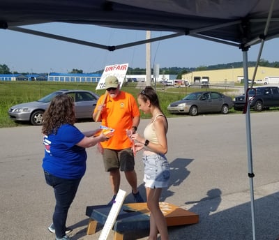 Woman in blue shirt speaking with two people on a picket line