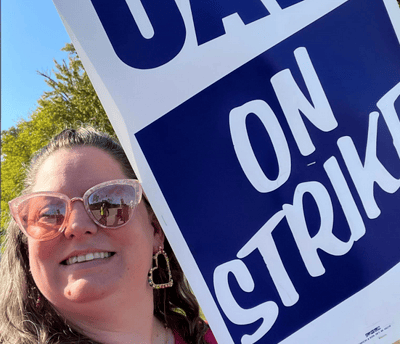 Woman in sunglasses holding strike sign