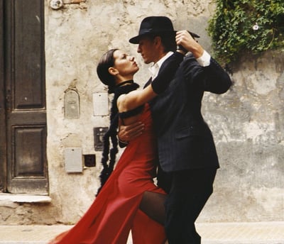 a man and woman dancing in a street
