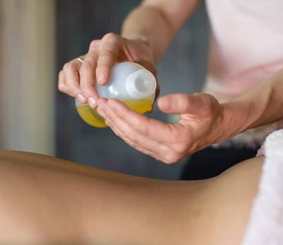 Massage ayurvédique à l’huile chaude sur le dos, soin bien-être relaxant et rééquilibrant.