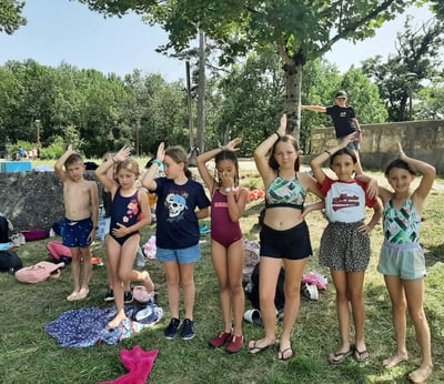 7 enfants en vacances qui font le signe du requin