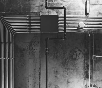 Neatly organized exposed electrical conduits on an industrial concrete wall for MEP planning.