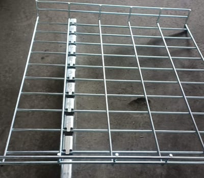 una bandeja de cables de malla de alambre soportada por un soporte metálico