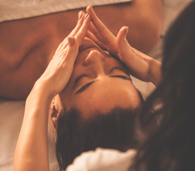 woman receives facial massage in beauty salon