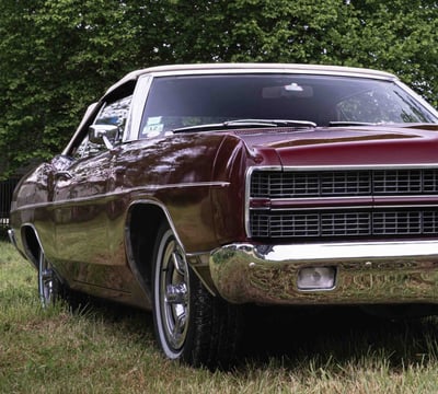 a car parked in the grass near a tree