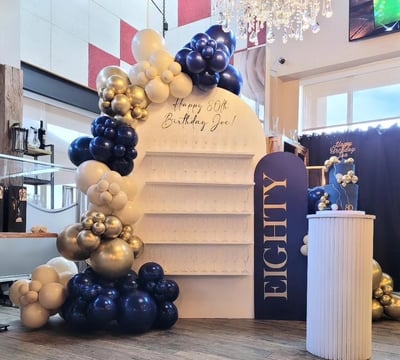 Balloon garland paired with our champagne/treat wall for an 80th birthday