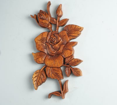 a wooden carved rose flower on a wall