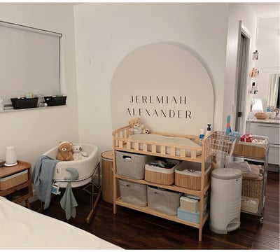 Organized nursery corner with labeled baskets, changing station, and soft neutral decor.