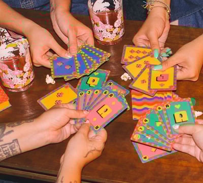 a group of people holding cards and playing cards