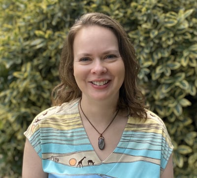 Woman smiling and standing in front of garden