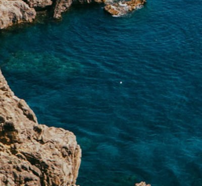 a person standing on a cliff overlooking a body of water