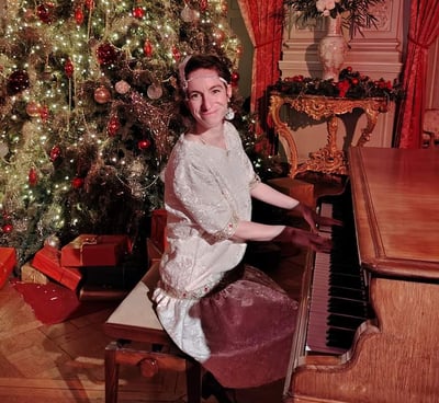 chanteuse pianiste en tenue belle époque dans un décor de noël dans un chateau