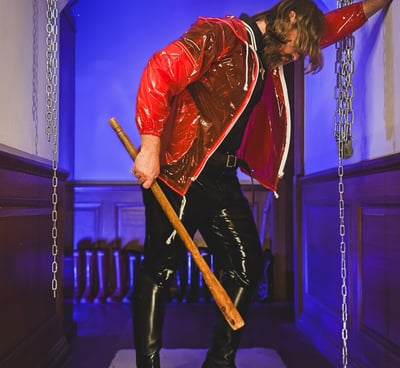 FTSH Studios model (s) Oscar Thickk UK Fetish Model wearing red vinyl jacket, latex shirt and leather riding boots