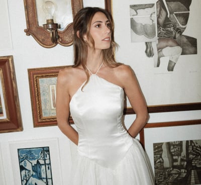 Bride with a simple half uo half down hairstyle showcasing her elegant dress by Nous Nous