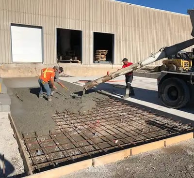 a man is pouring concrete into a concrete slab