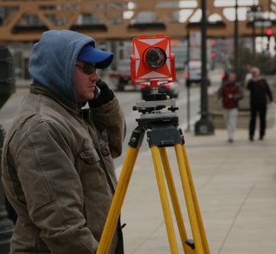 a man in a blue jacket and a camera on a tripod