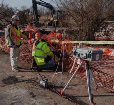 a man in a yellow vest and a camera on a tripod