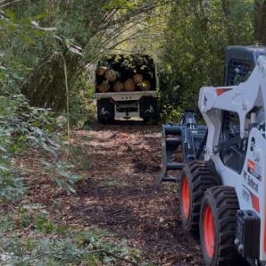 a tractor with a loader on it's back in the woods