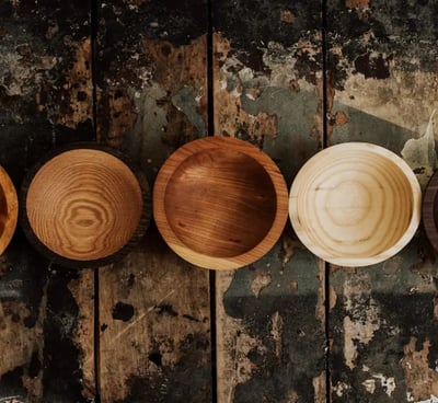 a row of wooden bowls with wooden bowls on them