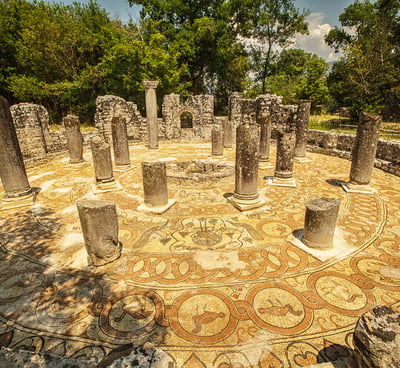 a circular stone mosaic tile flooring with a circular mosaic design