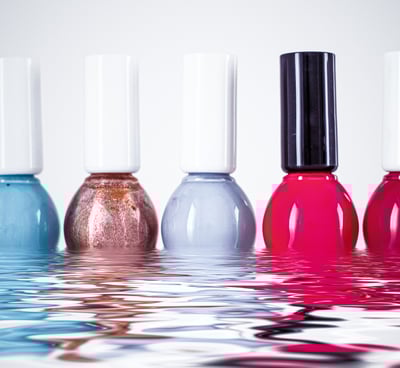 a group of five different colored nail polishes