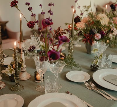 a table with a table setting with a candle and candles