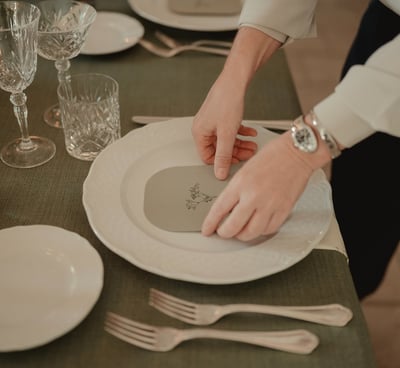 a person is setting a table with a plate of food