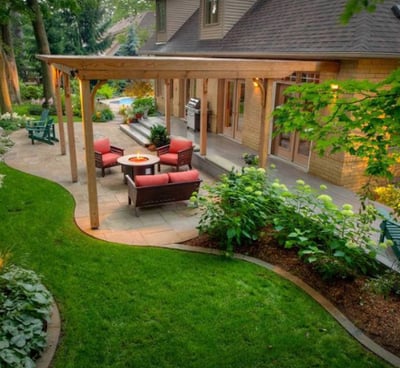 a patio with a table and chairs in the grass