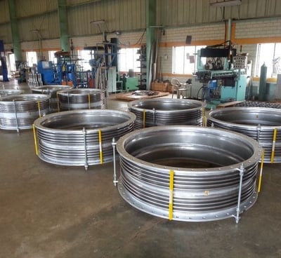 a large group of metal pipes and pipes in a warehouse