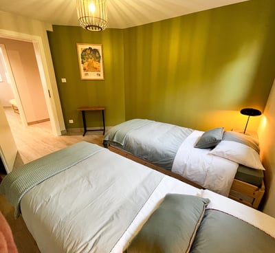 a bedroom with two beds and a lamp
