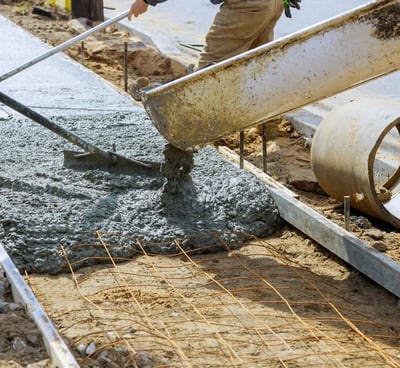 a man is pouring concrete into a concrete slab