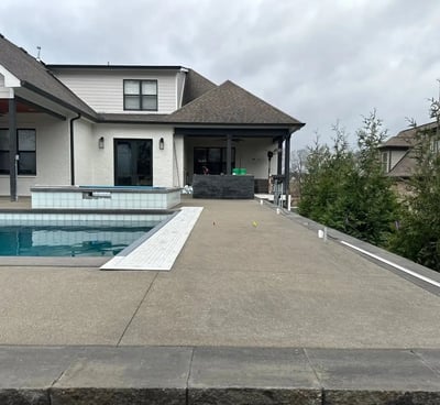 a pool with a concrete pool and a concrete patio